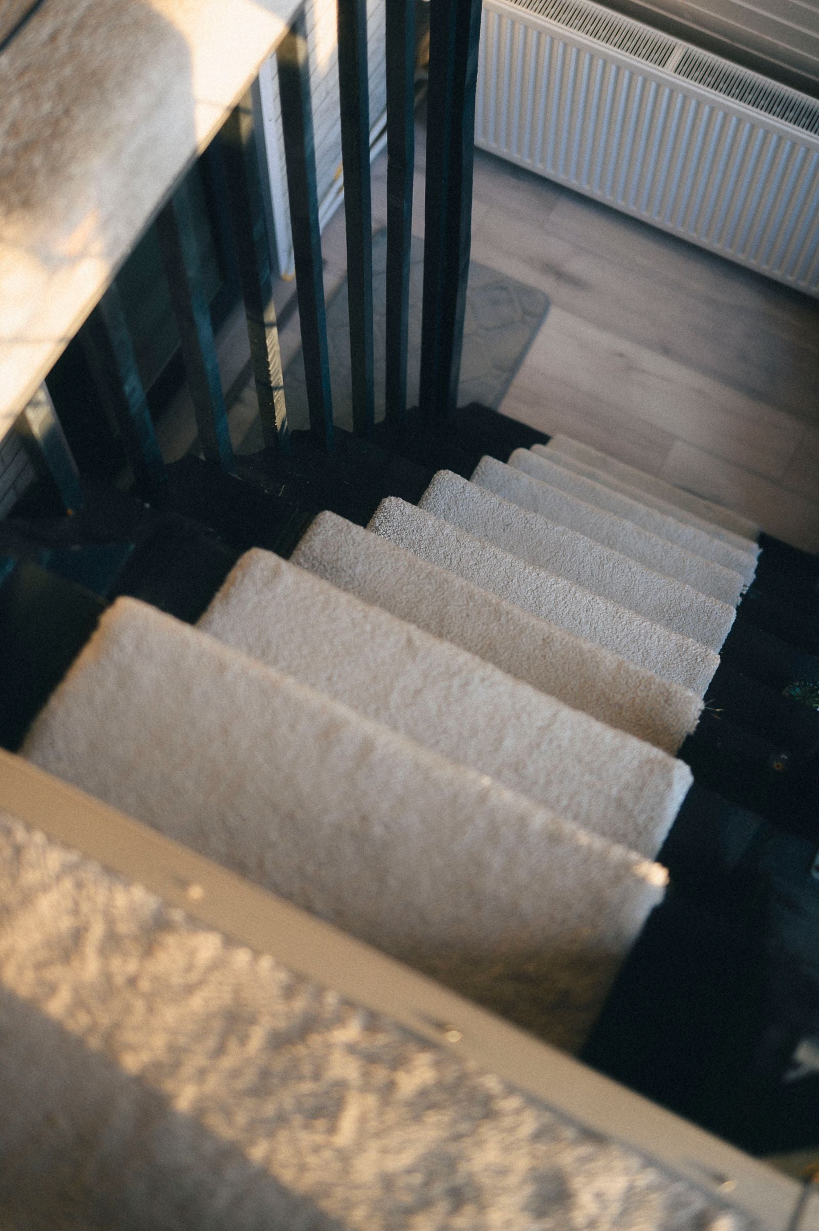 Looking down a carpeted staircase showing the treads and nosings