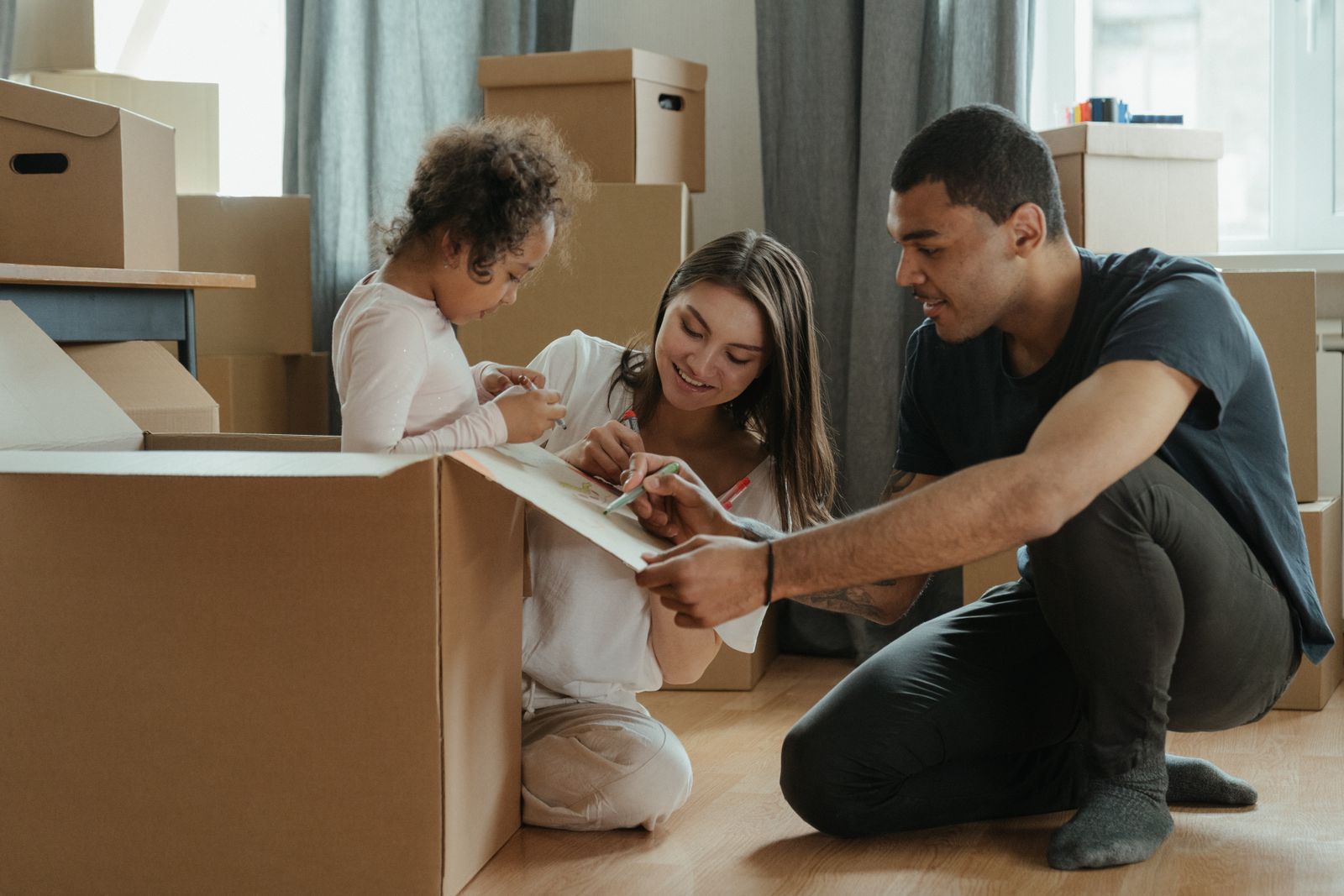 A family packing moving boxes in their living room