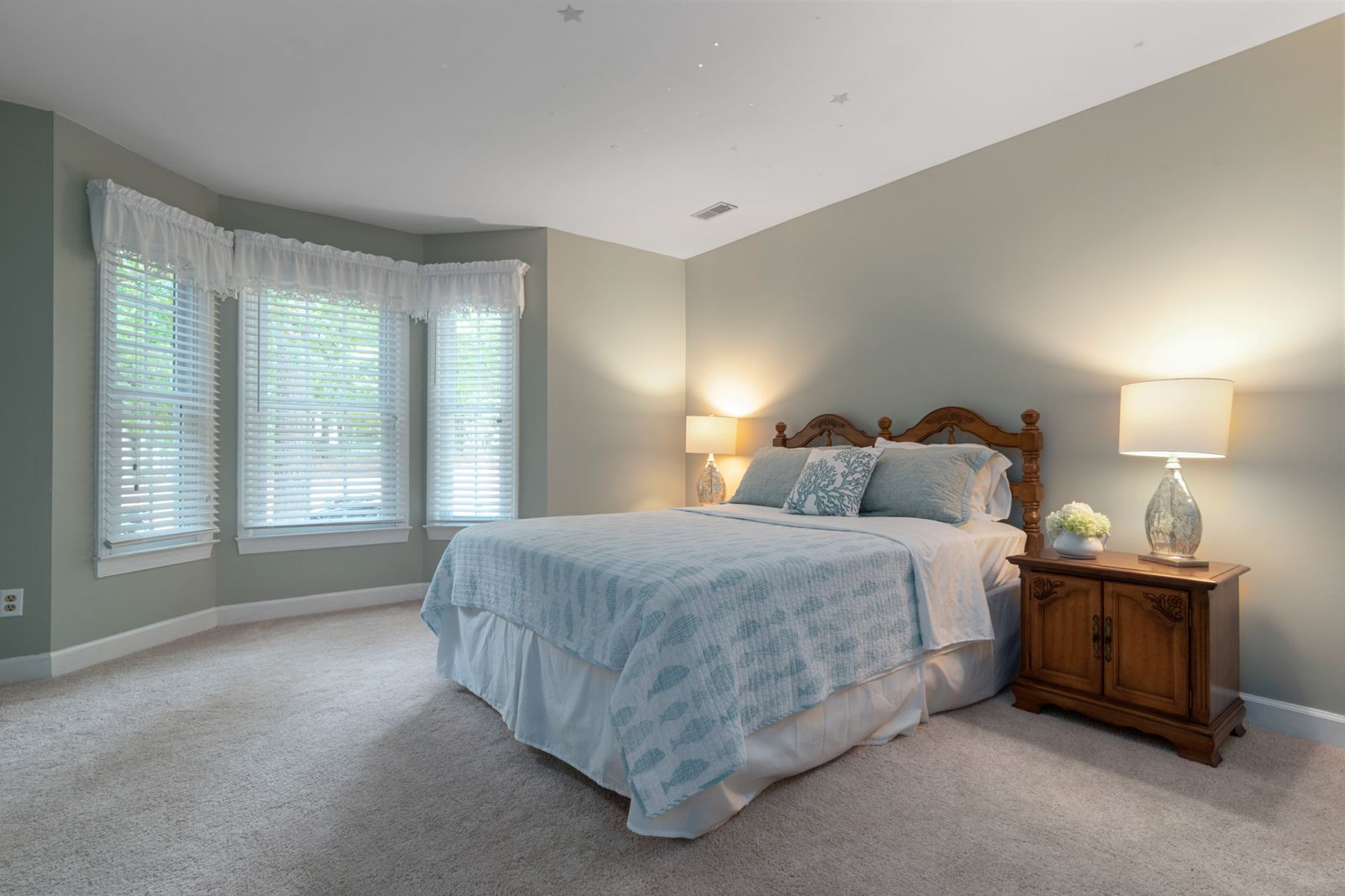 A carpeted bedroom with natural light, where dust mites and allergens collect