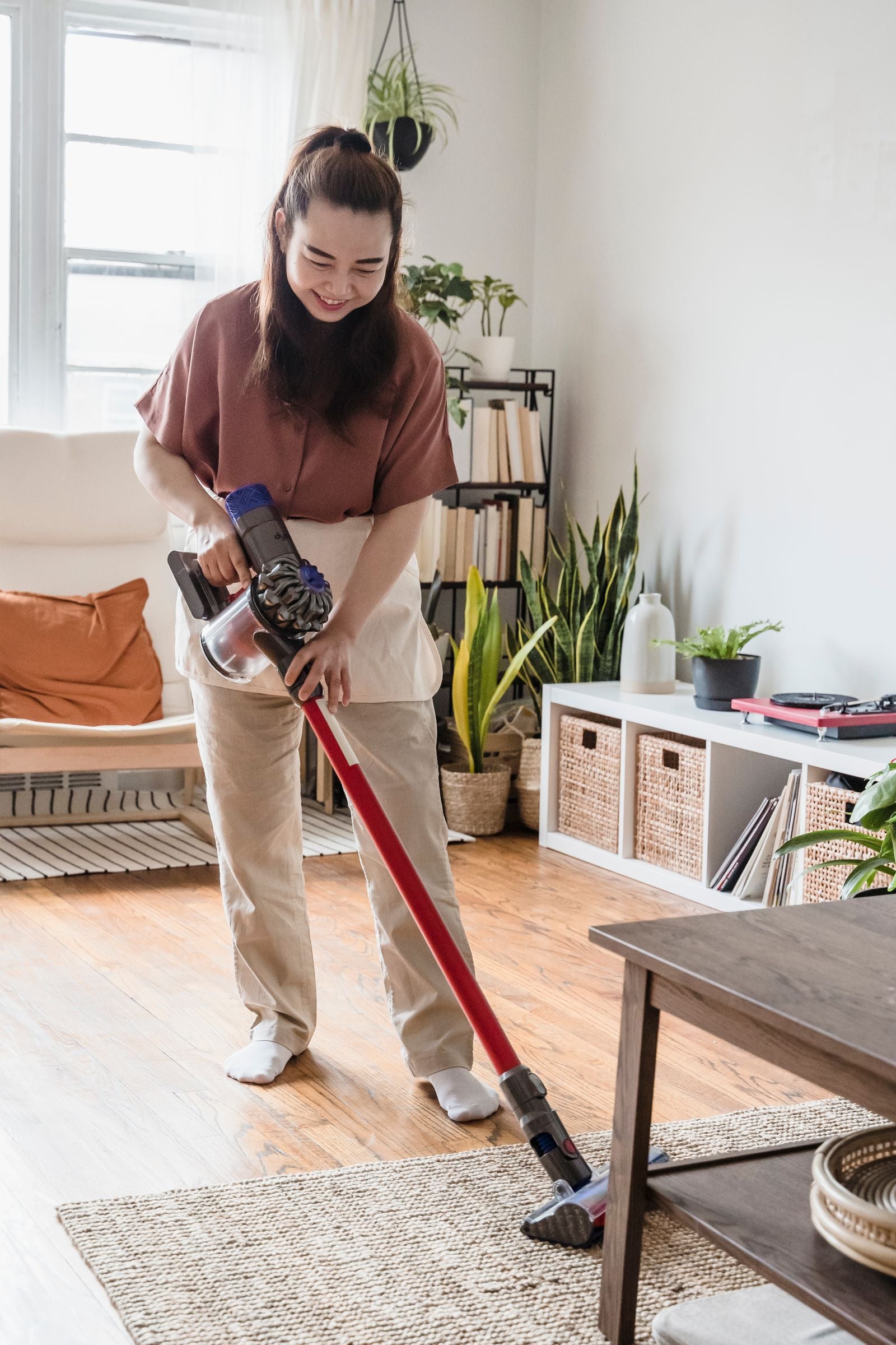 Vacuuming a woven rug in a bright living room